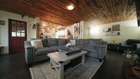 push in shot of a grey l-shaped couch in the living room of a farmhouse