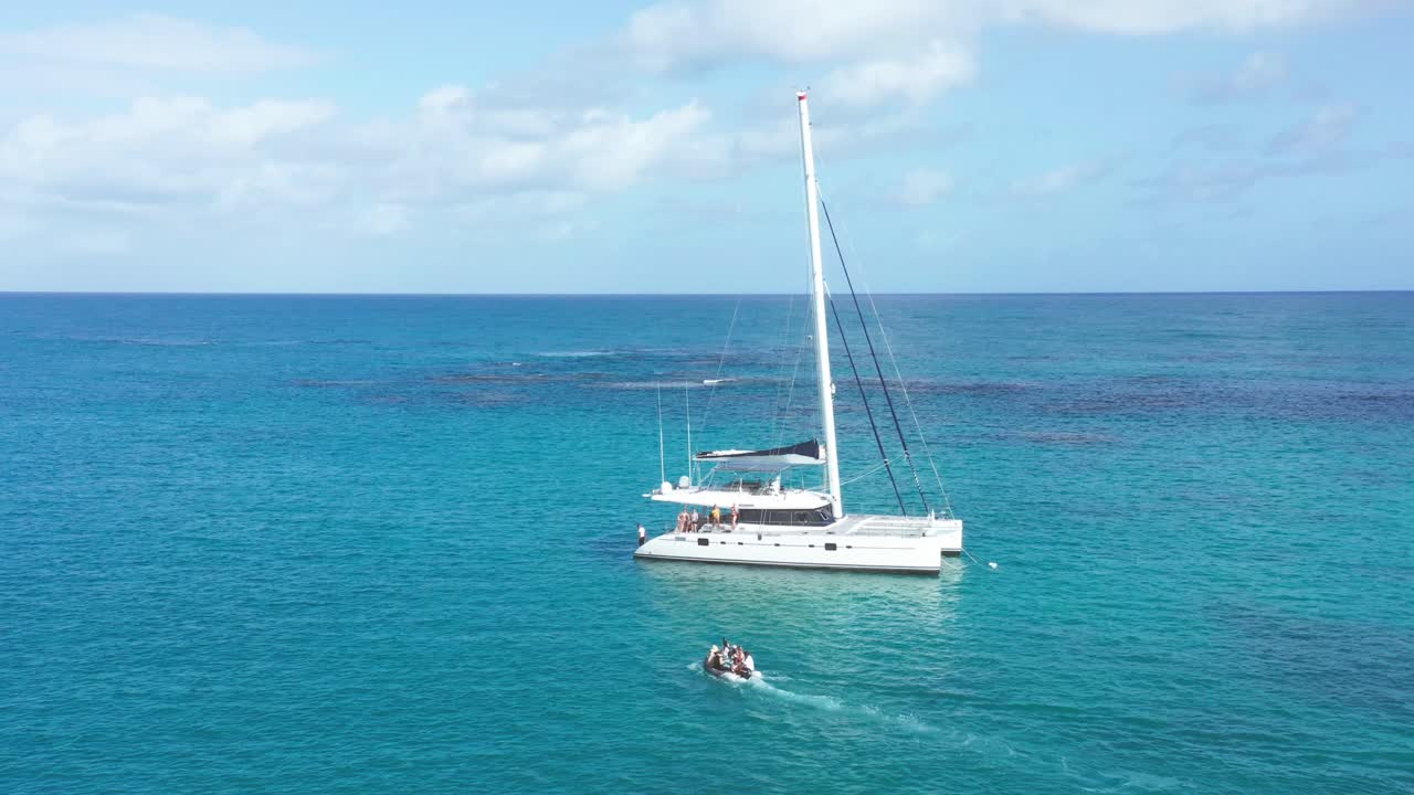 turistas transportados a catamarán con bote inflable, caribe azul celeste