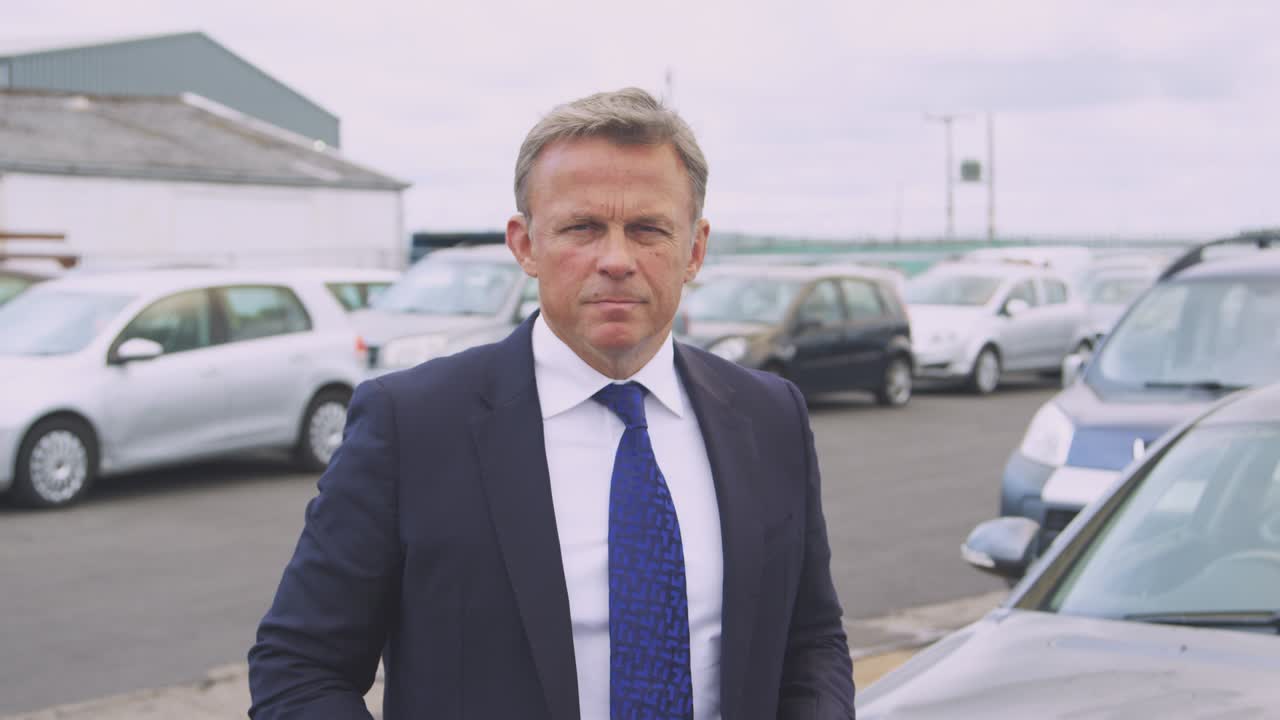 retrato de un ajustador de pérdidas de seguros con una tableta digital inspeccionando los daños al automóvil por un accidente automovilístico