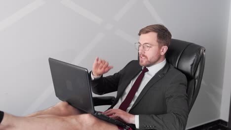 businessman sitting in chair talking on video call