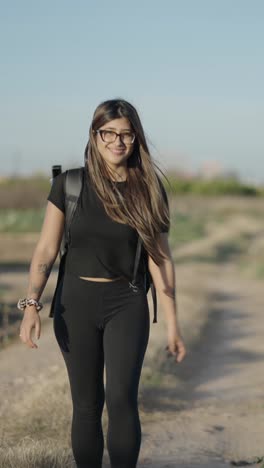 young woman walking outdoors with a backpack