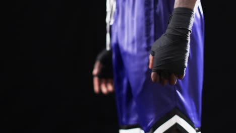 close-up of an athlete's hands wrapped for combat sports on a black background