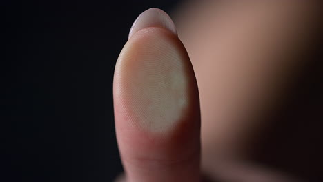 marco of female fingerprint on glass surface indoors. manicured finger.