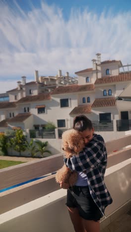 girl hugging her dog on a balcony