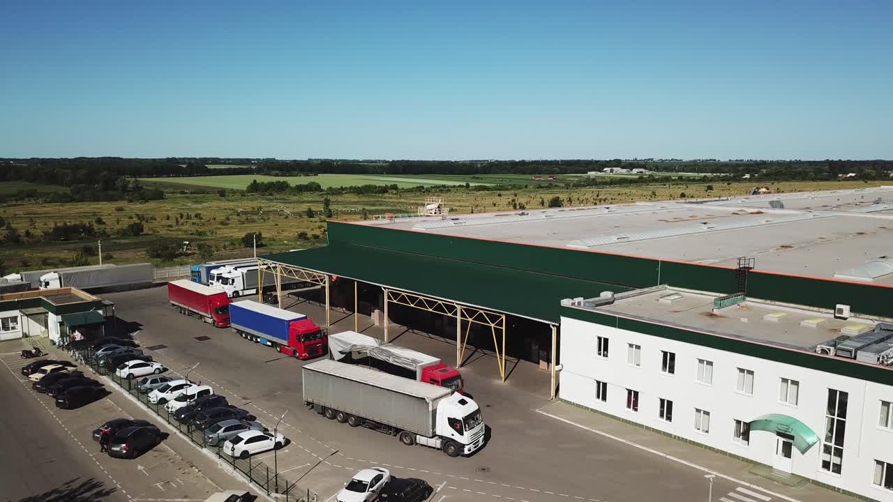 Aerial view of a big factory and a parking lot in the front.