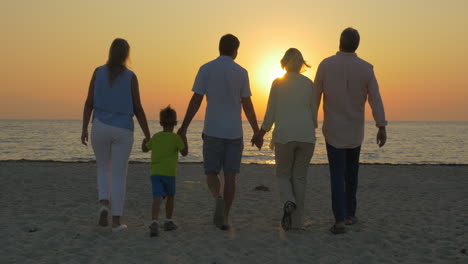 Familie-Blickt-Auf-Den-Goldenen-Sonnenuntergang-über-Dem-Meer