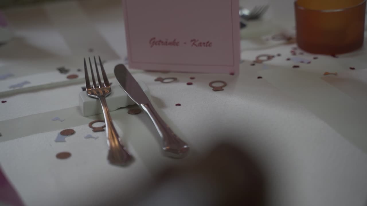 cubiertos en una mesa blanca en una boda con decoraciones y un menú para la cena