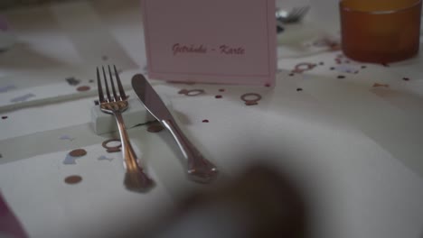 cutlery on a white table at a wedding with decorations and a dinner menu