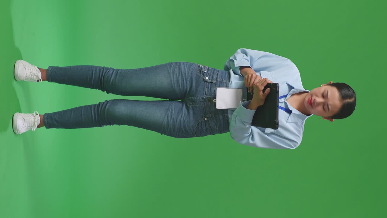 cuerpo lleno de mujer de negocios asiática no está satisfecha y sacude la cabeza mientras usa la tableta en el estudio de pantalla verde