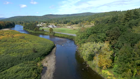 aerial view of a serene river running through a picturesque farmland