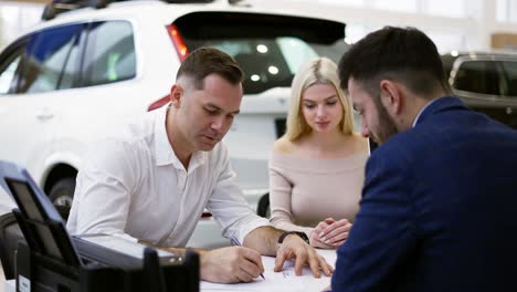 la compra familiar de un coche nuevo, la firma del contrato en la sala de exposición
