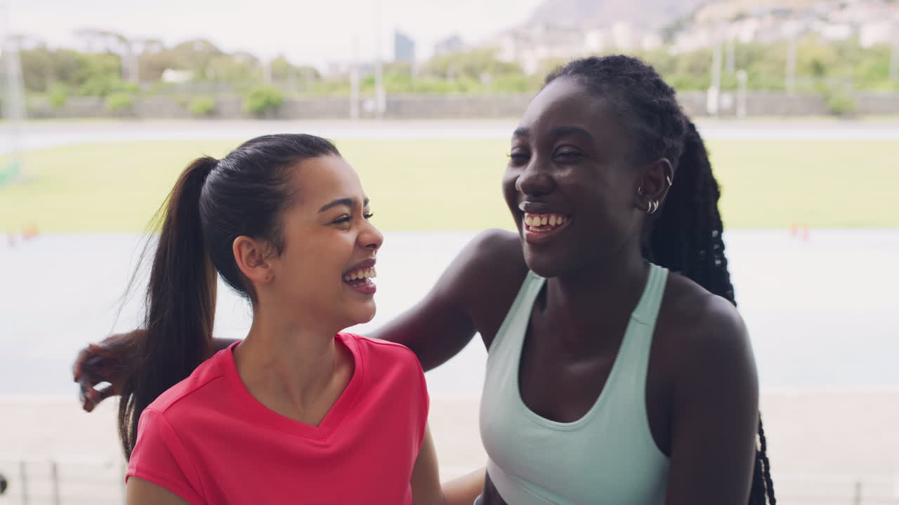 Portrait of female athletes hugging while training