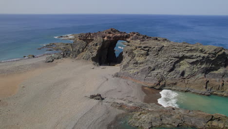 Isla-De-Fuerteventura:-Vista-Aérea-Viajando-Hacia-El-Arco-Del-Jurado-Y-La-Playa-En-Un-Día-Soleado-Con-Hermosos-Colores