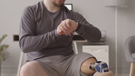 man with prosthetic leg listening to music on fit ball during training