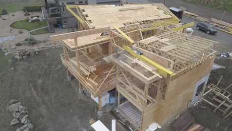 an aerial drone shot of a house overlooking a lake being constructed