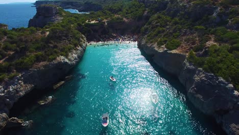 beautiful crystal blue water lagoon, boats sailing on beautiful water. mallorca cala d'or spanish coast and beautiful beach.