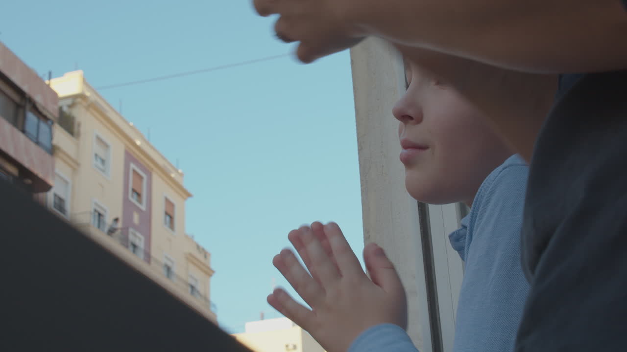 어린 소년은 의료진에게 감사를 표하기 위해 박수를 치고 있습니다.