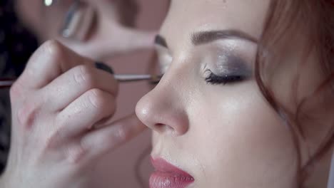 make-up artist paints the eyes of the bride in the morning before the wedding close-up slow motion