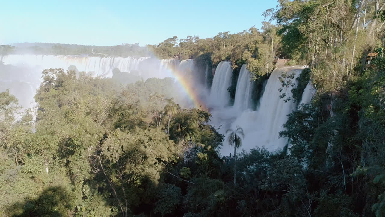 drone alejándose de una parte de las cataratas de iguazu, en el lado argentino, con un hermoso arco iris sobre las cataradas