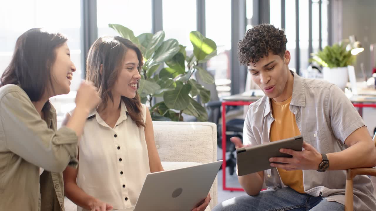 Team reviewing social media on laptop, tablet; woman typing, pointing for review, likes appearing