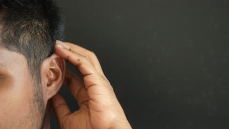 close up of a man's ear and hand