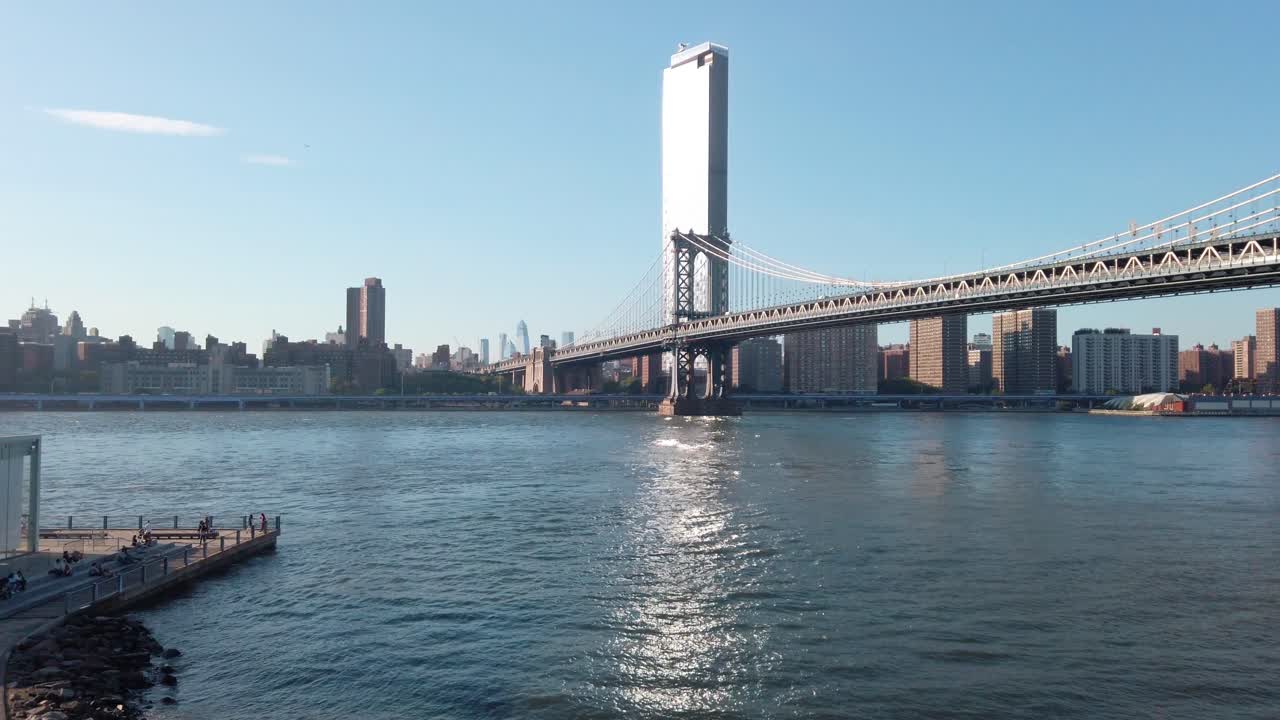 Epica inquadratura del Ponte di Manhattan: la telecamera passa attraverso le braccia per rivelare un uomo adulto afroamericano che si gira