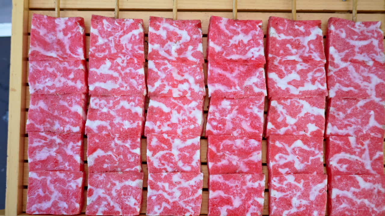 Close up of multiple pieces of Wagyu beef on a wooden tray at a street food market in Japan