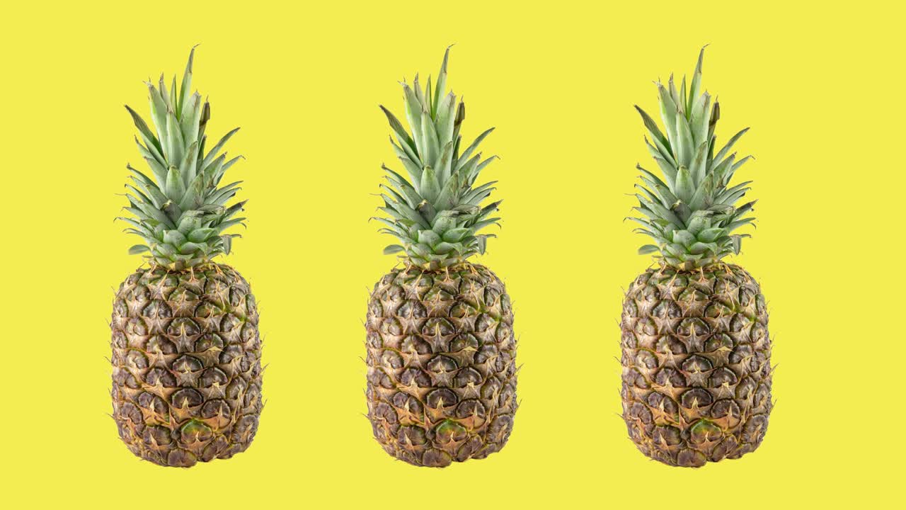 stop motion animation with three ripe fresh pineapples rotating on yellow background. concept of travel with copy space