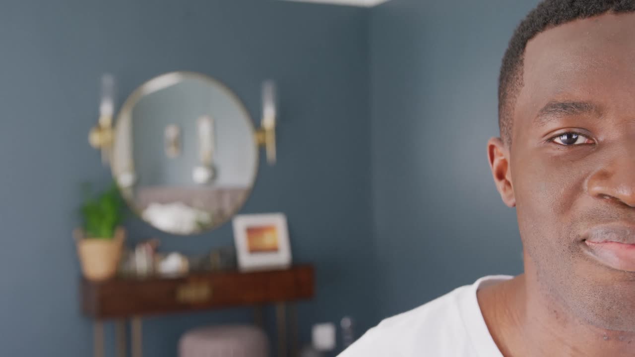 Ritratto video di metà del viso di un uomo afroamericano che sorride a casa, con spazio per il testo.