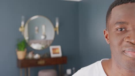 retrato de video de la mitad de la cara de un hombre afroamericano sonriendo en casa, con espacio para copiar.