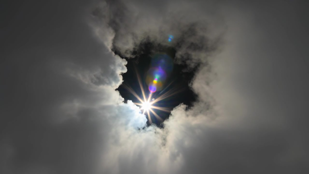 Rivelando un'apertura tra le nuvole dal suolo mentre il sole fa capolino e le nuvole in movimento si aprono, con la formazione di un bagliore dell'obiettivo.