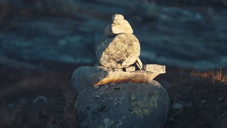 first rays of the rising sun light up the stone cairn