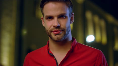 Portrait-handsome-guy-looking-camera-indoors.-Relaxed-man-posing-in-dark-space.