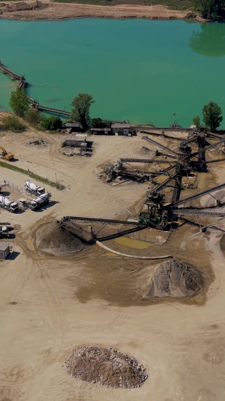 Aerial drone view of aggregate sorting plant at a quarry site. Sand and gravel separation system connected with industrial production and construction material supply.