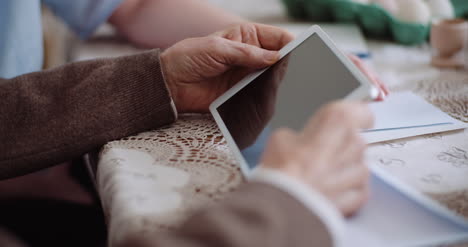 granddaughter with grandfather using digital tablet 2