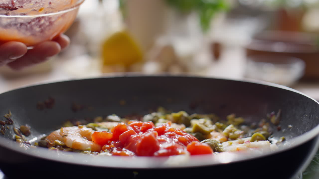 Adding Diced Tomatoes to Ingredients in Frying Pan