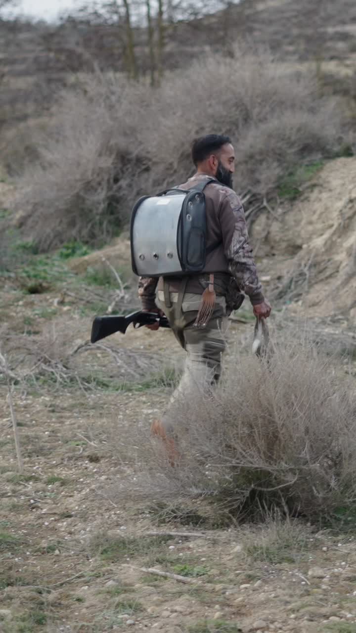 Hunter with rabbit and shotgun in the field