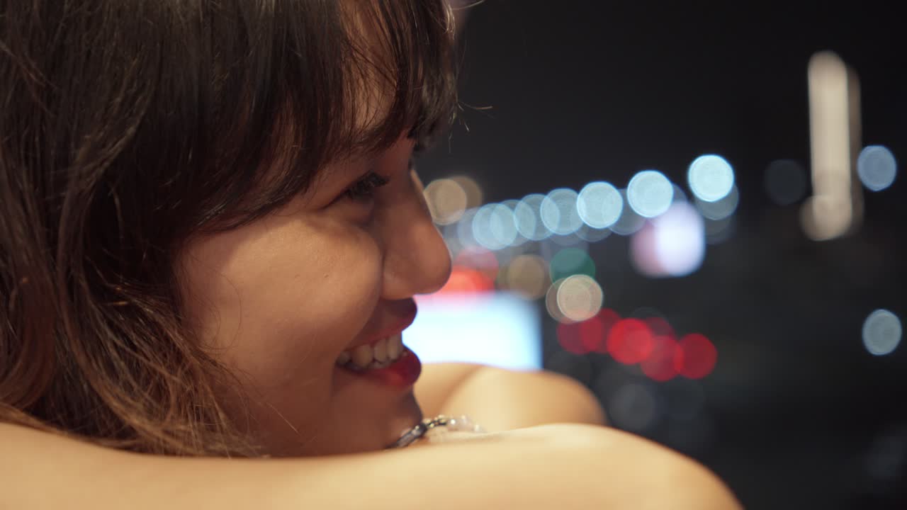 Close-up Portrait Of A Teenager Smiling With Bokeh City Lights Backdrop.