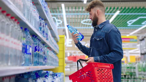 hombre comprando botellas de agua en una tienda de comestibles