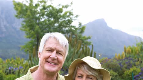 Smiling-senior-couple-standing-together-in-garden
