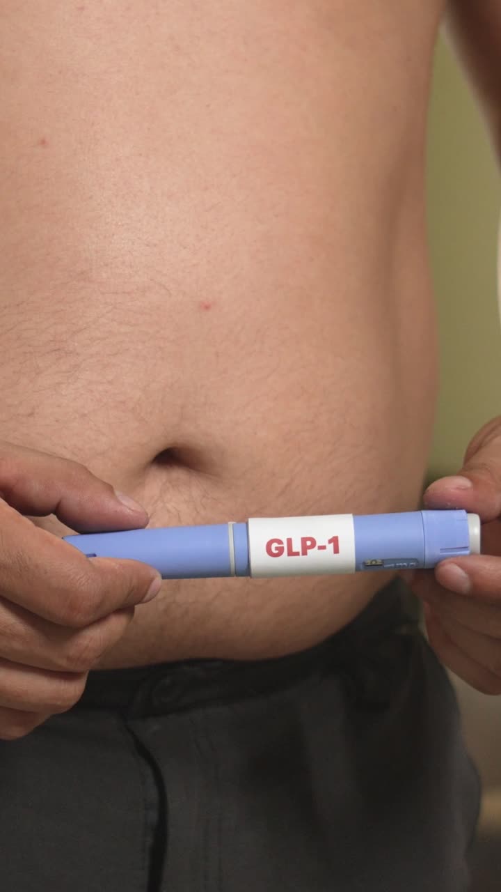 Uomo in sovrappeso che prepara una penna per farmaco GLP-1, supporto per la sindrome metabolica, innovazione sanitaria.