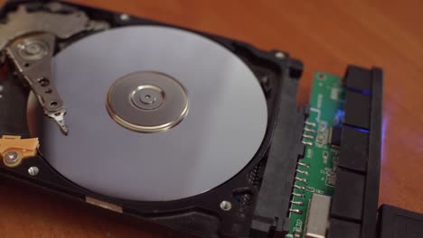 hard disk is lying on table, blinking and spinning disk. work of hacked