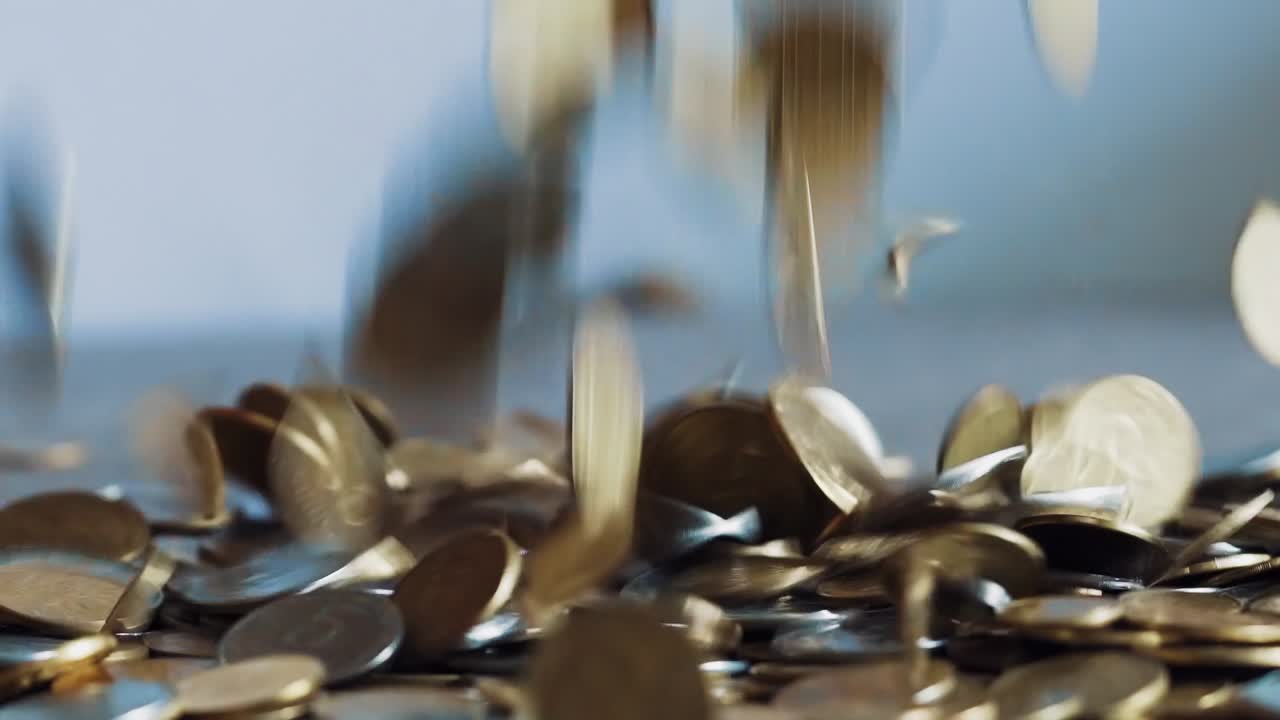 Closeup slow motion dropping coins