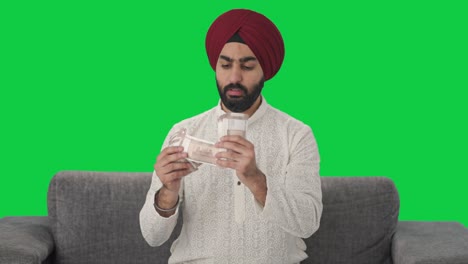 Sikh-Indian-man-counting-money-Green-screen