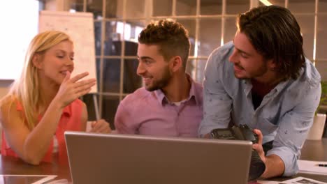 Creative-businessman-showing-coworkers-his-camera