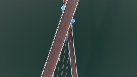 tracking drone view of x-shaped bridge and clean water reflection at masan marine park, south korea.