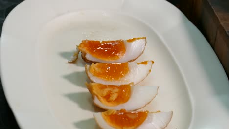 Close-up-Footage-of-Whole-Deep-Fried-Egg-with-Juicy-Yolk-Displaying-on-the-White-Plate