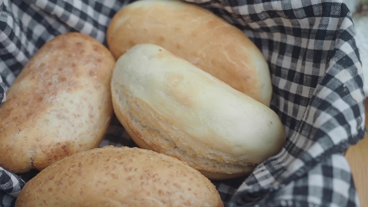 Freshly baked bread rolls in a checkered cloth