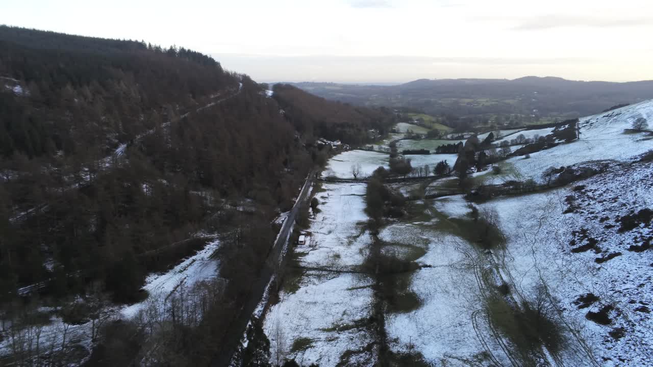 Verschneite, ländliche walisische Waldlandschaft am Moel Famau im Winter: Luftaufnahme, Kamerafahrt nach rechts