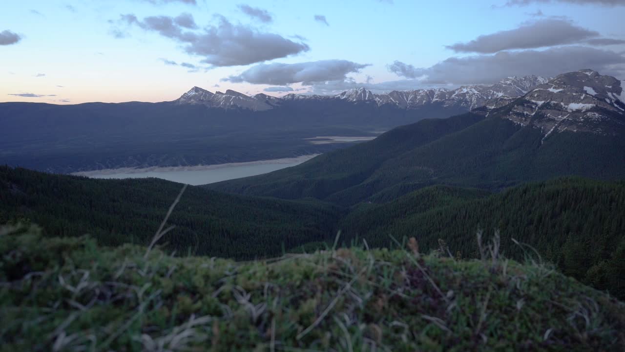 hermoso paisaje de una cordillera con picos rocosos en un gran valle verde por la noche, toma panorámica, concepto de conservación
